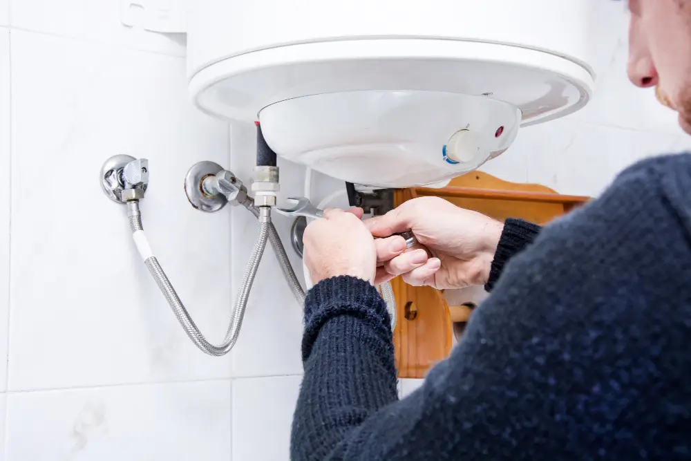 Plumber repairing a water heater in Oshawa